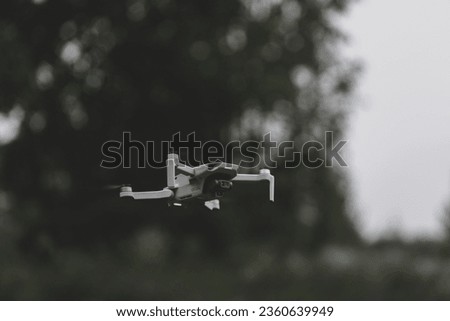 Little drone in the air if front of trees