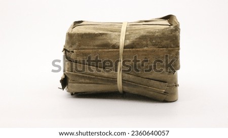 Indonesian rice cake covered in banana leaves on a white background