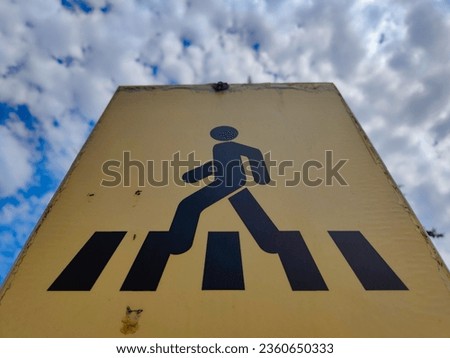 old pedestrian crossing sign and cloudy sky