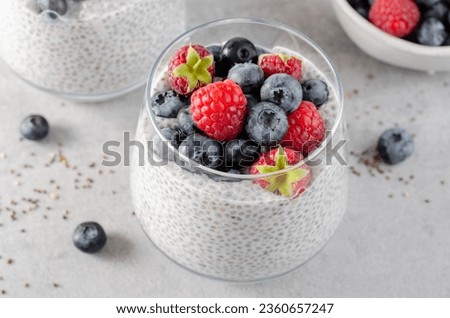 Healthy Chia Pudding in a Glass with Fresh Berries on Bright Background Royalty-Free Stock Photo #2360657247