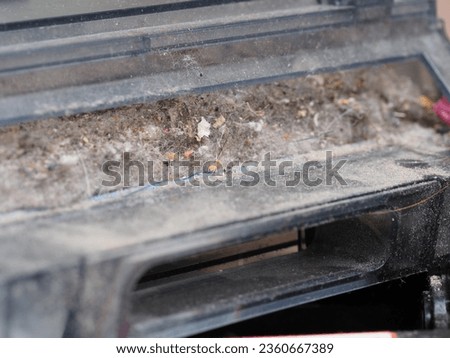 a dust container collected by a robot vacuum cleaner Royalty-Free Stock Photo #2360667389