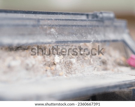 a dust container collected by a robot vacuum cleaner Royalty-Free Stock Photo #2360667391