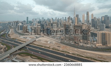 Panoramic skyline of Dubai with business bay and downtown district with traffic on al khail road. Aerial view of many modern skyscrapers and construction site before sunrise. United Arab Emirates.