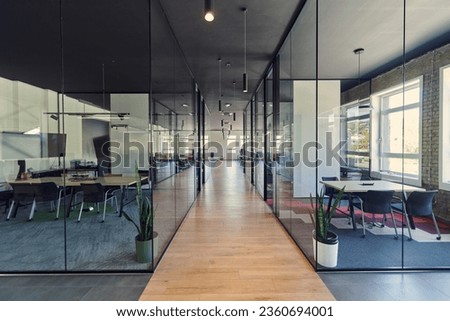 In a setting of modern, glass-walled business startup offices, the open, airy workspace reflects a contemporary and innovative ambiance, promising a dynamic environment for entrepreneurial growth Royalty-Free Stock Photo #2360694001