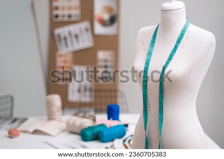 Tape measure on bare mannequin with pins in sewing studio tailor equipment for dressmaking in modern craft workshop headless dummy in fashion sewing studio