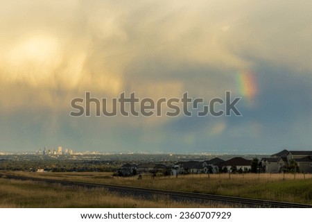 Rainbow Over Denver. Colorado Stormy Sky with Colorful Rainbow. Downtown Denver Skyline is Visible in the Distance