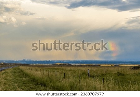 Rainbow Over Denver. Colorado Stormy Sky with Colorful Rainbow. Downtown Denver Skyline is Visible in the Distance