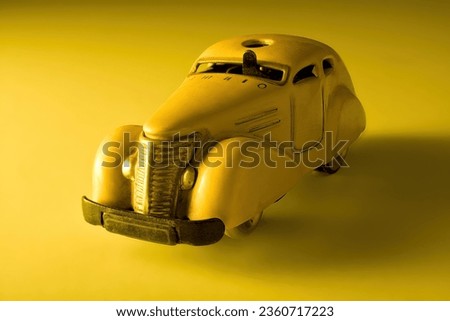 Old vintage toy car on yellow background