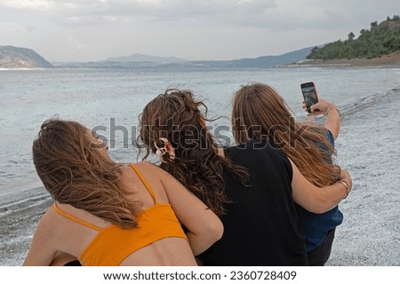 Women taking selfies with their mobile phones.