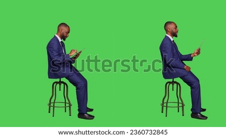Male employee browsing online and using videocall on digital tablet, attending business meeting teleconference. Young adult in formal suit working with modern device over greenscreen.