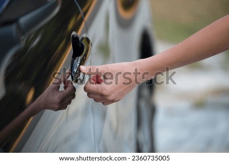 Closeup of driver hand opening car front door with touch ID finger imprint scanning technology. Vehicle safety concept Royalty-Free Stock Photo #2360735005