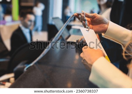 Process of checking in on a conference congress forum event, registration desk table, visitors and attendees receiving a name badge and entrance wristband bracelet and register electronic ticket
 Royalty-Free Stock Photo #2360738337