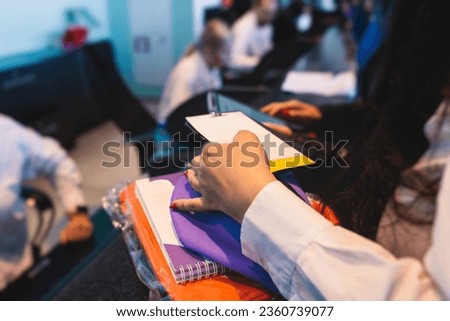 Process of receiving gift bag package for conference participants before start, with a leaflet handout, notebook notepad, t-shirt, mug, pen, pencil, corporate gifts and souvenirs for employees  Royalty-Free Stock Photo #2360739077
