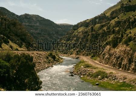 The Wind River Mountain Range and Canyons in the northern Wyoming countryside, during summer with a flowing river between canyons, with a film-like and cinematic color grade. Royalty-Free Stock Photo #2360763061