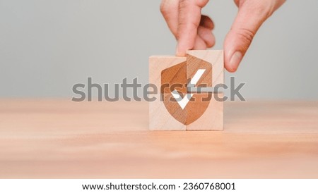 Hand put a wooden cube block with identity proof icon for security protection system on wood table. Quality assurance of business service. Certified guarantee approval or secure access system concept. Royalty-Free Stock Photo #2360768001