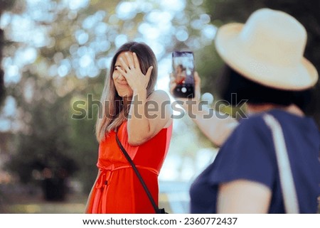 
Woman Hiding her Face from Someone Filming Her in Public. Stressed person feeling uncomfortable with being photographed 
