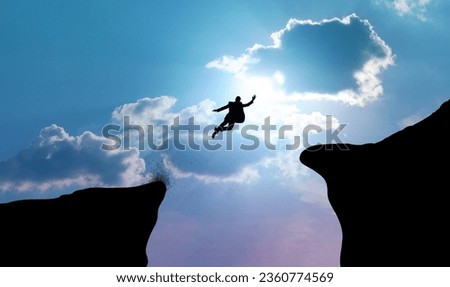 Silhouette of businessman leaping or jumping across two cliffs. Business concepts of decision-making, courage, and risk-taking for success. Royalty-Free Stock Photo #2360774569