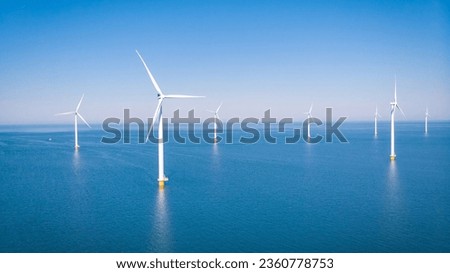 Offshore Windmill farm in the ocean Westermeerwind park, windmills isolated at sea on a beautiful bright day Netherlands Flevoland Noordoostpolder. Huge windmill turbines Royalty-Free Stock Photo #2360778753