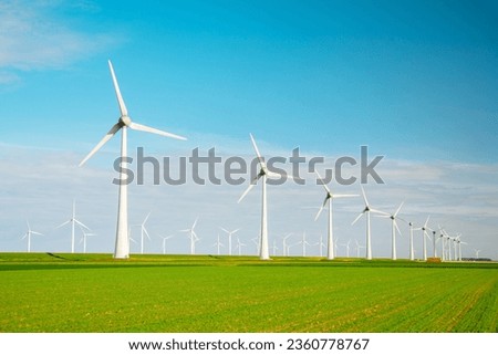 offshore windmill park with clouds and a blue sky, windmill park in the ocean aerial view with wind turbine Flevoland Netherlands Ijsselmeer. Green Energy in the Netherlands Royalty-Free Stock Photo #2360778767