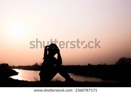 Silhouette of woman praying over beautiful sky background
