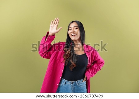 Lifestyle, people emotions and casual concept. Friendly cheerful asian woman smiling, saying hi and waving hand to greet person, make hello gesture, welcome someone Royalty-Free Stock Photo #2360787499