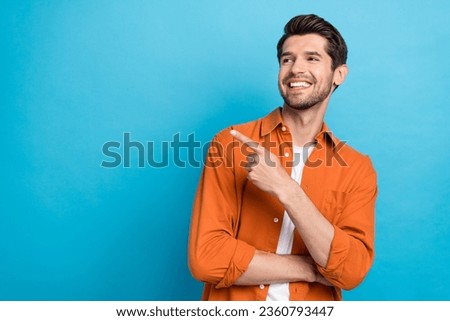 Photo of attractive dreamy man dressed orange shirt looking showing finger empty space isolated blue color background Royalty-Free Stock Photo #2360793447