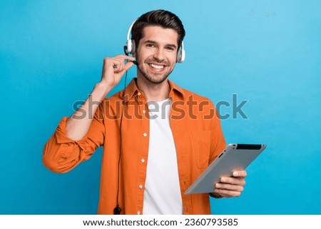 Photo of good mood cheerful guy wear orange shirt receiving calls contact center isolated blue color background Royalty-Free Stock Photo #2360793585
