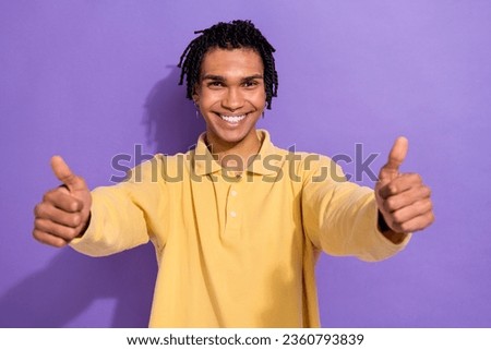 Photo of positive glad man wear yellow trendy clothes demonstrate two hands thumbs up cool feedback isolated on purple color background