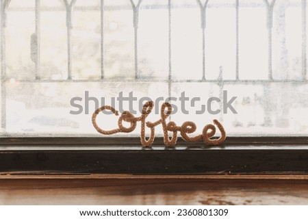 Fancy wire shaped into word COFFEE stand on the edge of cafe window.