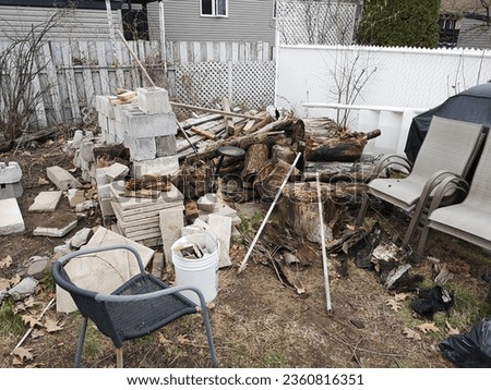 Image example showing a very messy backyard with piled debris and tree trunk logs in desperate need of junk removal service. Royalty-Free Stock Photo #2360816351