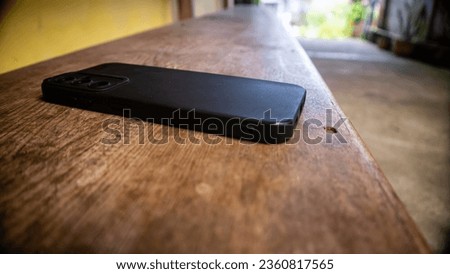 black smartphone on wooden stool