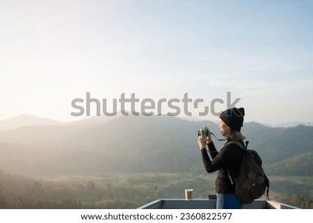 Hiker photographer taking picture of valley with mountains from view point. woman wearing hat stand alone and enjoying freedom and calm inspired travelling. Tourist traveler on background view mockup