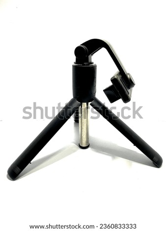 Black mini tripods made of metal. Photo taken at close range with a white background