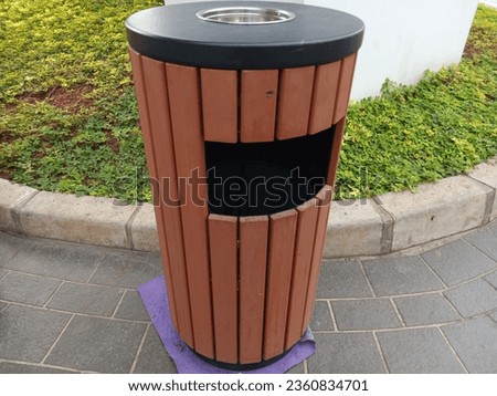 Unique trash can made from a combination of wood and iron on top