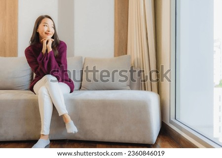 Portrait beautiful young asian woman smile relax on sofa in living room interior