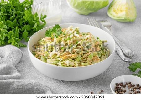 Traditional cole slaw salad in a bowl on a gray concrete background. Salad with cabbage, carrot and mayonnaise sauce. Selective focus, copy space Royalty-Free Stock Photo #2360847891