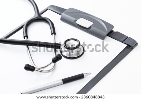Binder and stethoscope on a white background.