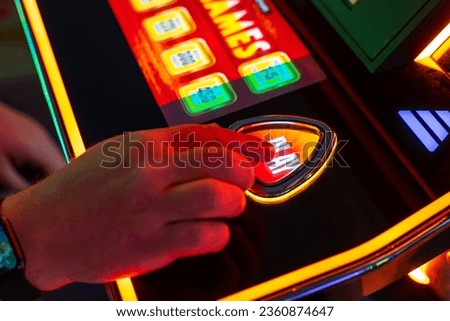 A man presses the button to play the slot machine. A man playing slot machine. Royalty-Free Stock Photo #2360874647
