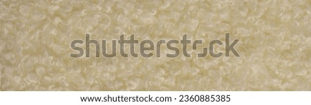 Faux fur of white pale yellow color. Imitation of karakul lamb skin. known as fleecy fabric, which resembles animal fur in appearance and warmth.