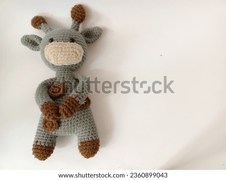 gray with brown dots giraffe dolls holding hand  knitting or Handmade Knitted Doll. Crochet stuffed animals on white Background.

