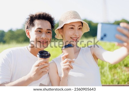 Young Asian couple taking self photograph at the park