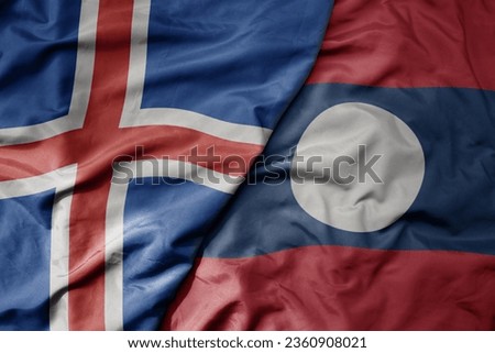 big waving national colorful flag of icelandic and national flag of laos . macro