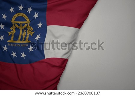 big waving national colorful flag of georgia state on the gray background. macro