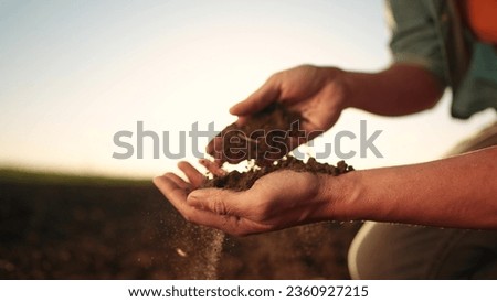 soil in the hands of the farmer. agriculture. close-up of farmers hands holding sun black soil in their hands, fertile land. garden field ground fertile concept. worker holding soil plowed field Royalty-Free Stock Photo #2360927215
