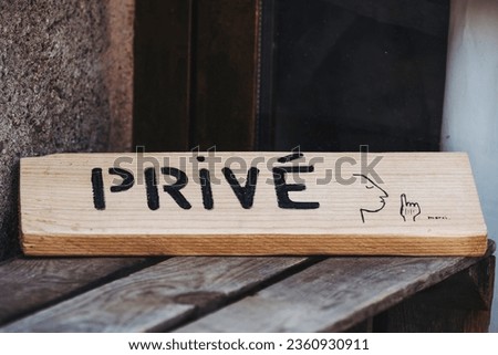 Wooden plaque at the entrance to a house with “private” text information