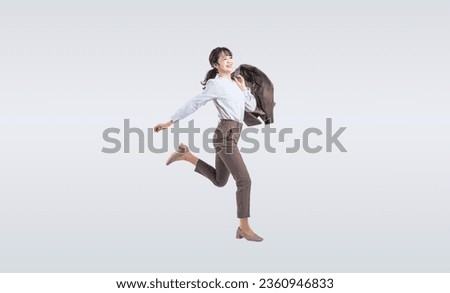 Asian middle-aged business woman in a suit jumping energetically.