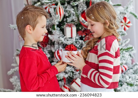 Portrait of happy children with Christmas gift boxes. Two kids having fun at home. Winter holidays concept. High angle view portrait