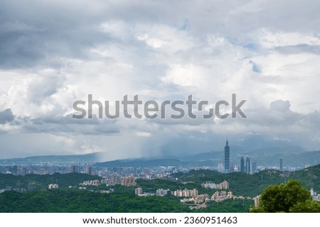 Dynamically changing and diverse layers of white clouds over the city. White clouds, green mountains and city buildings form a picture.