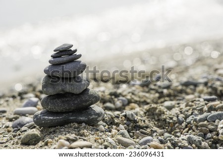 Stacked sea stones. Sea on the background. Contra light