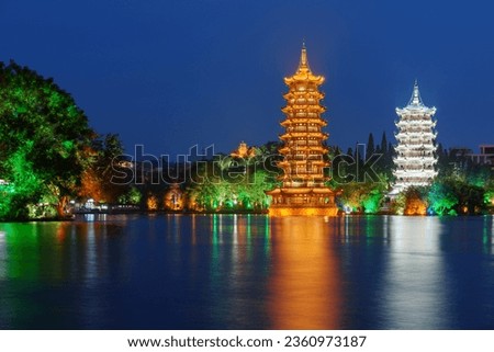 Beautiful night view of the Sun and Moon Twin Pagodas at Shanhu Lake (Fir Lake). Gold and Silver Pagodas illuminated at downtown of Guilin, China. Guilin is a popular tourist destination of Asia. Royalty-Free Stock Photo #2360973187